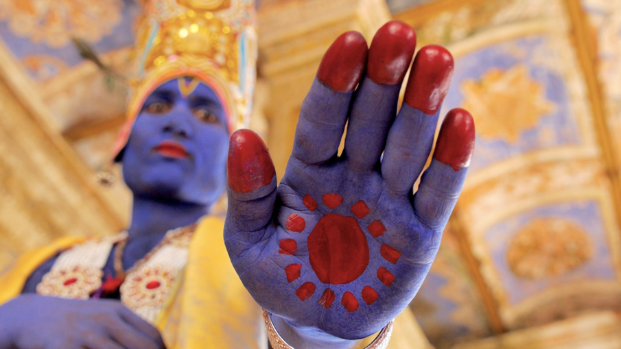 A still image from the film Sama in the Forest, where an actor playing Lord Krishna is cursing his daughter.